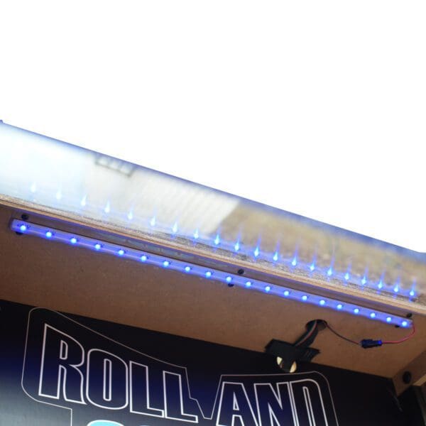 A blue Shooting Star 9-ft Roll Hop and Score Arcade Game Table with LED Scoring is on top of a Rolland truck.