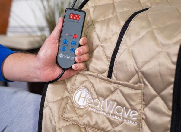 A person holding a Valerian Portable Sauna over a heated bag.