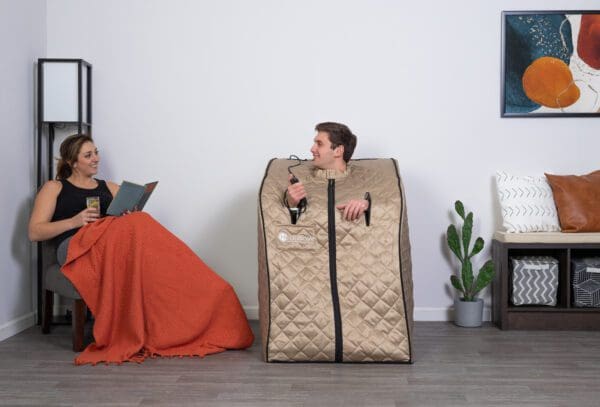 A man and woman sitting in a Valerian Portable Sauna.