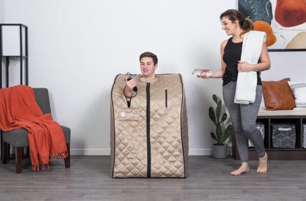 A woman is standing next to a man in a Valerian Portable Sauna.