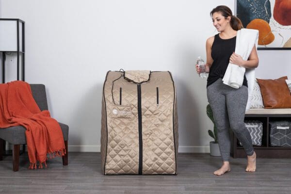 A woman standing next to a Valerian Portable Sauna.